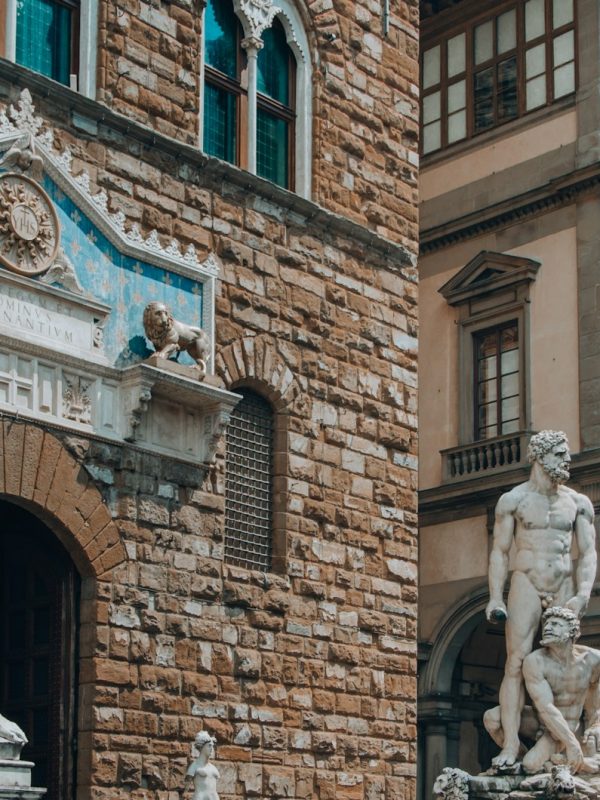 white horse statue near brown brick building during daytime